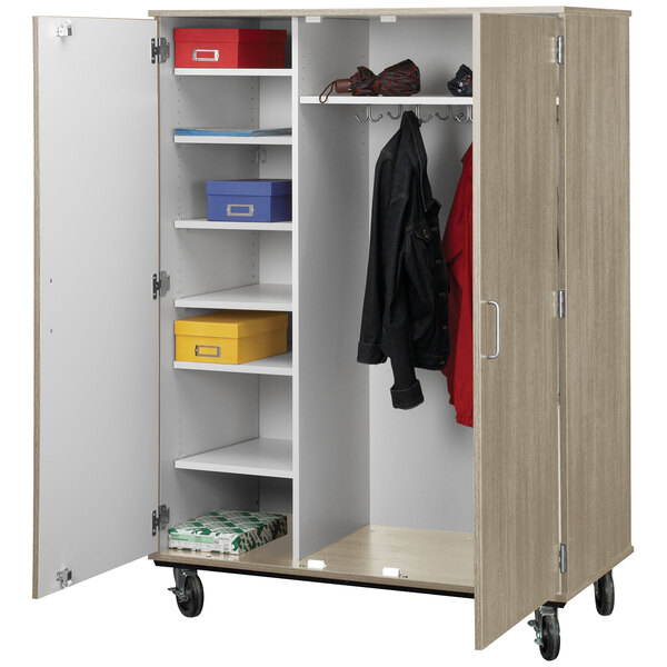 A closet with a red coat hanging on it.