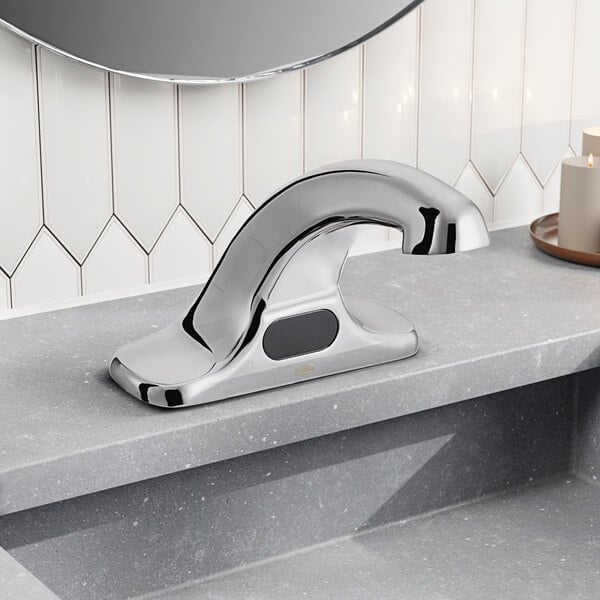 A Zurn Elkay silver electronic faucet with a black sensor on a counter.