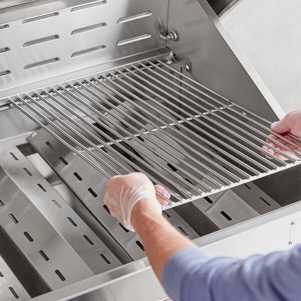 A person holding a Backyard Pro grill cooking grate.