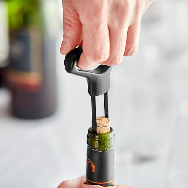 Person using a wine cork extractor to uncork a wine bottle