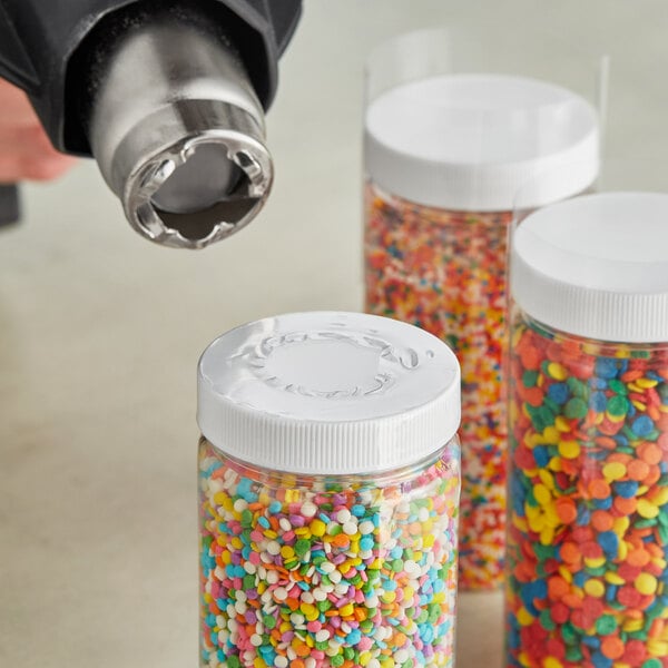 A jar of colorful sprinkles with a clear shrink band over the cap.