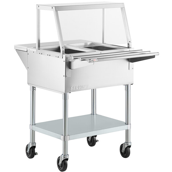 A ServIt stainless steel electric steam table with an angled glass sneeze guard and tray slide.