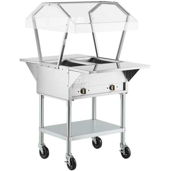A silver ServIt electric steam table on wheels with a clear cover.