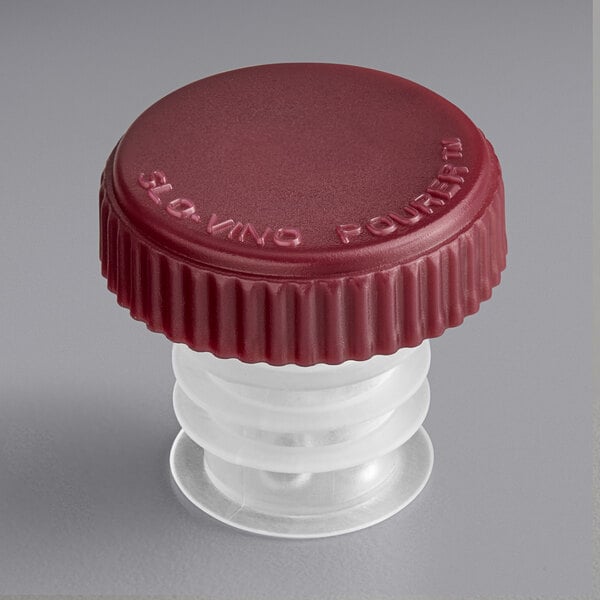 A red plastic cap with a white lid on a Franmara Slo-Vino wine pourer.