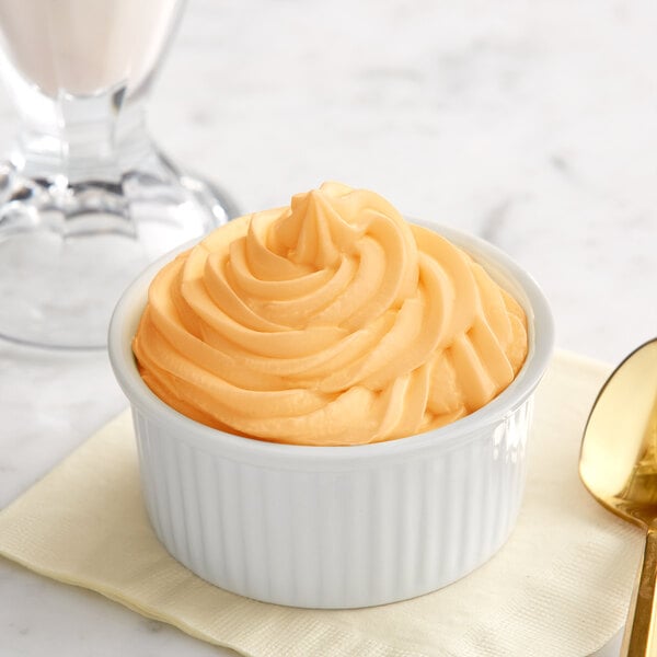 A bowl of orange soft serve ice cream.