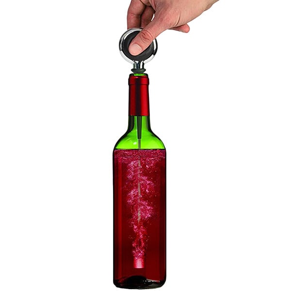A hand holding a Franmara Wine-Stone Wine Aerator over a wine bottle.