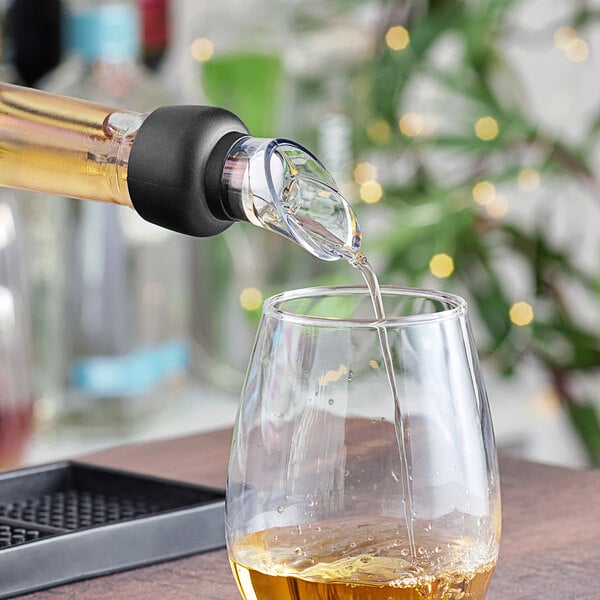 A Franmara black auto-close wine pourer pouring wine into a glass.