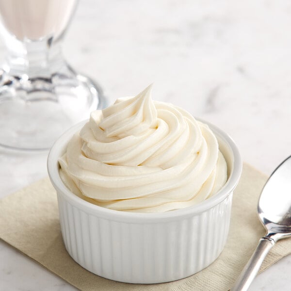 a bowl of ice cream with a spoon and a glass of milk