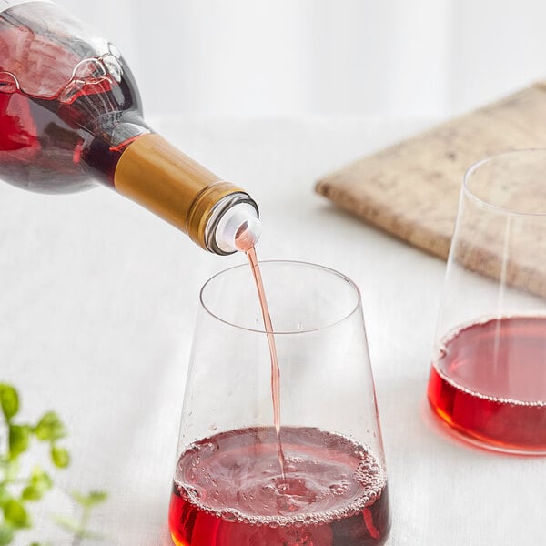 a bottle pouring red liquid into a glass