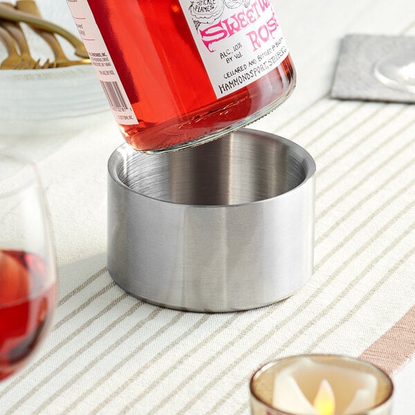 A bottle of wine being poured into a stainless steel Franmara wine coaster.