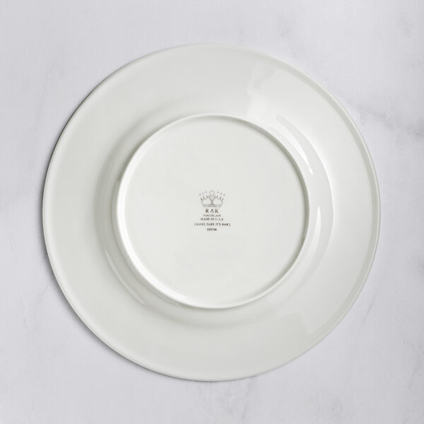 A RAK Porcelain ivory flat plate with an embossed design of a crown on the rim.