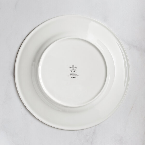 A close-up of a RAK Porcelain ivory wide rim plate with an embossed design.