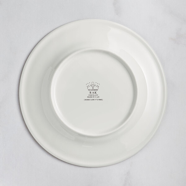 A white RAK Porcelain plate with an embossed crown logo on the rim.