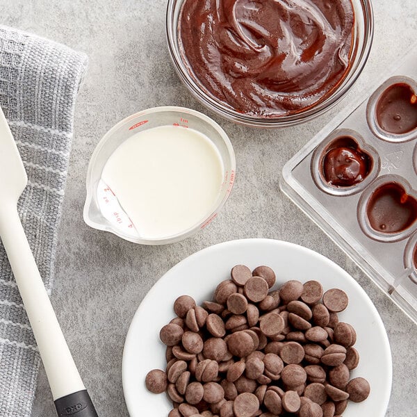 A bowl of Callebaut dark chocolate callets on a table.