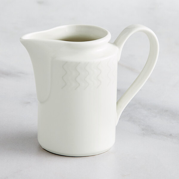 A RAK Porcelain ivory creamer with a handle.