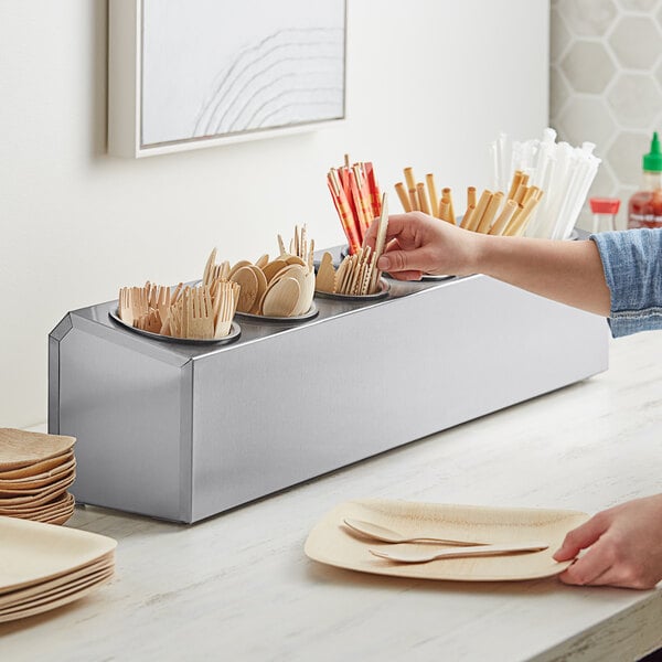 A woman using a Choice stainless steel flatware organizer to hold utensils.