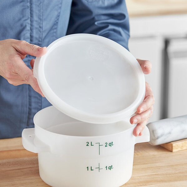 A person holding a white Vigor food storage container lid.