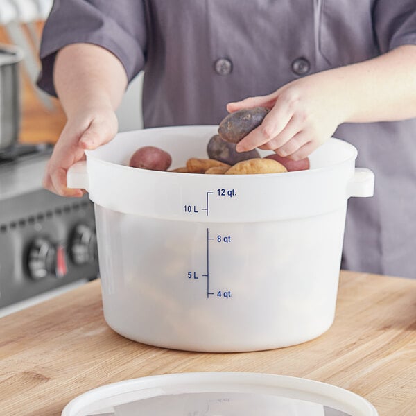 A person holding potatoes in a white Vigor food storage container.