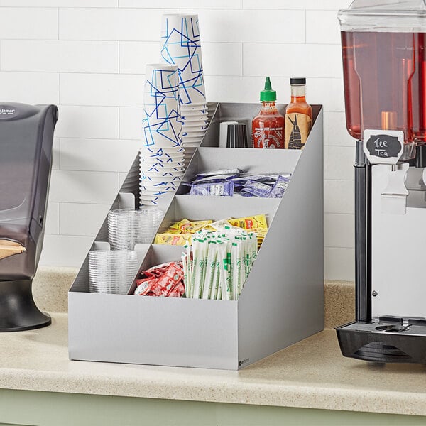 A ServSense stainless steel countertop cup and lid organizer on a counter with cups in it.