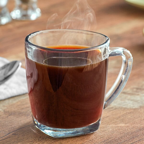 A glass cup of Crown Beverages Royal Reserve Sumatra Decaf coffee with steam coming out of it.