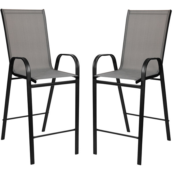 A Flash Furniture outdoor bar table set with 4 grey chairs with black metal legs.