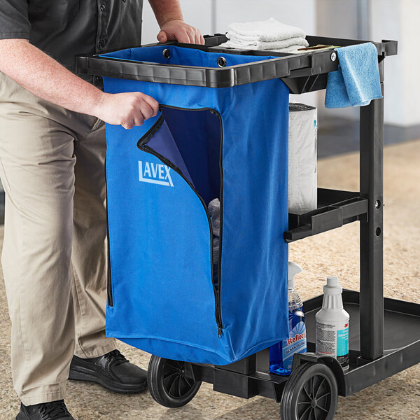 A person pushing a cleaning cart with a Lavex blue bag.