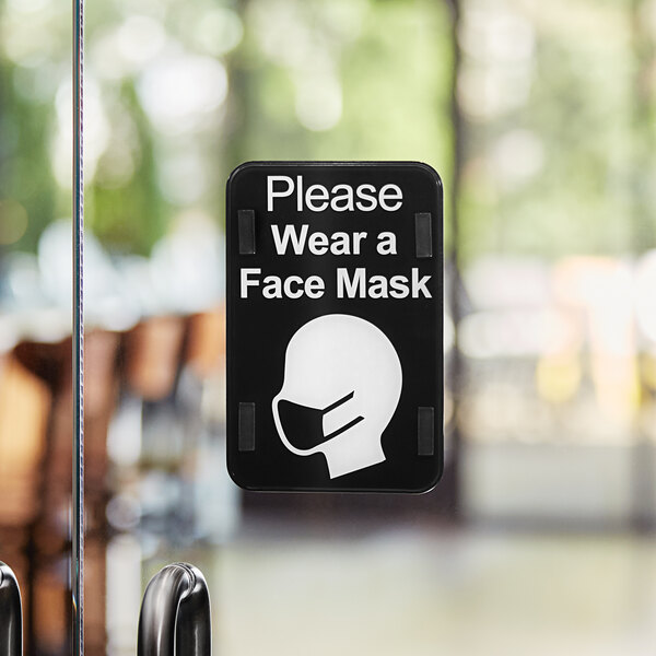 A Tablecraft "Please Wear a Face Mask" sign on a door.