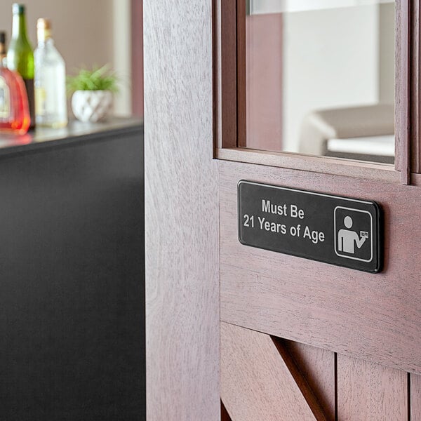 A Tablecraft "Must Be 21 Years of Age" sign on a door.