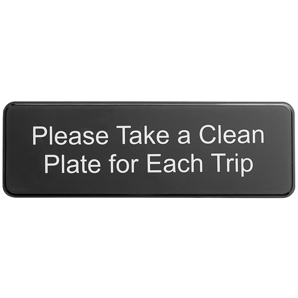 A black Tablecraft sign with white text that says "Please Take a Clean Plate for Each Trip" on a counter.
