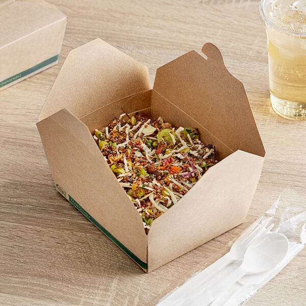 A Kraft EcoChoice take-out box filled with food on a table with a plastic spoon and fork.