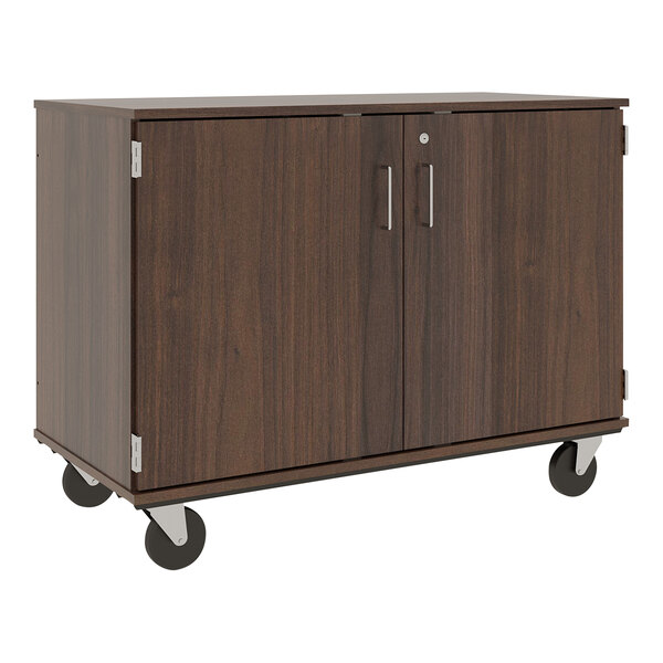 A dark walnut I.D. Systems mobile storage cabinet with silver handles and wheels.