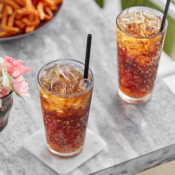 Two glasses of Pure Craft Beverages Root Beer Float with ice and straws on a table