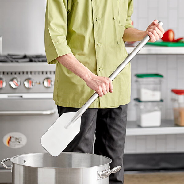 A person using a Fourté stainless steel paddle in a pot.