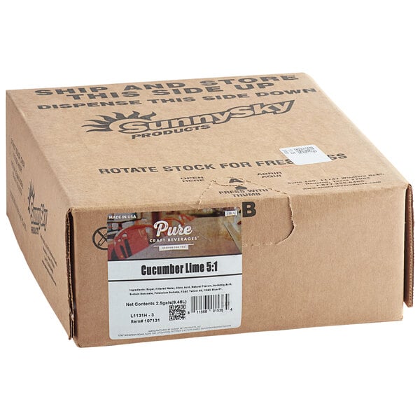 A brown cardboard box with a white label reading "Pure Craft Beverages Cucumber Lime Soda Syrup"