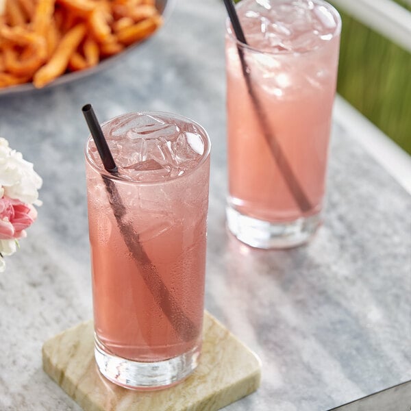 Two glasses of blueberry lemonade with straws on a marble table.