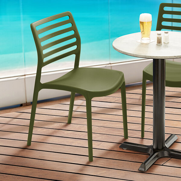 Two Lancaster Table & Seating Allegro olive green chairs on an outdoor patio.