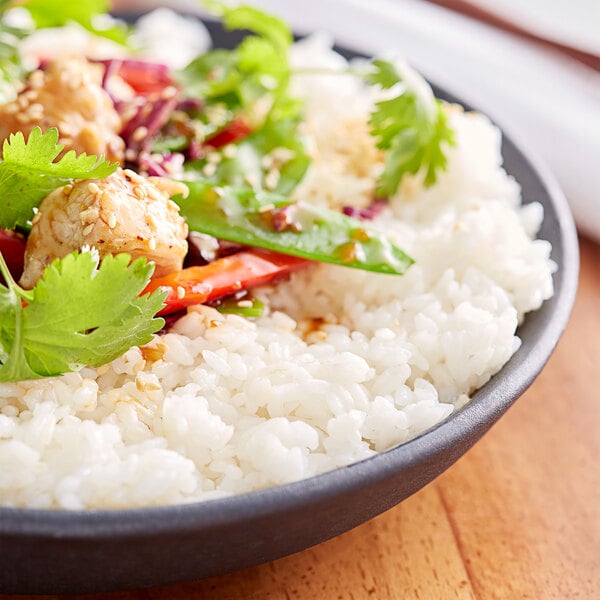 A bowl of Premium Medium Grain Rice with vegetables and meat on top.