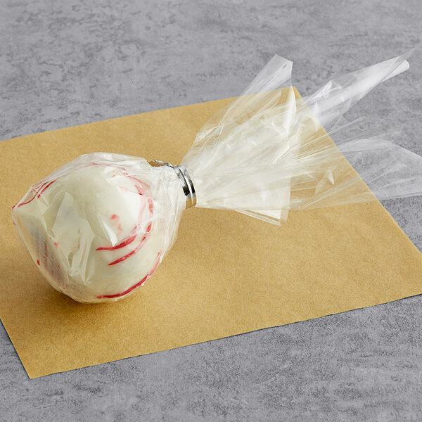 A white and red Chalet Desserts Red Velvet Cake Pop in plastic wrap.