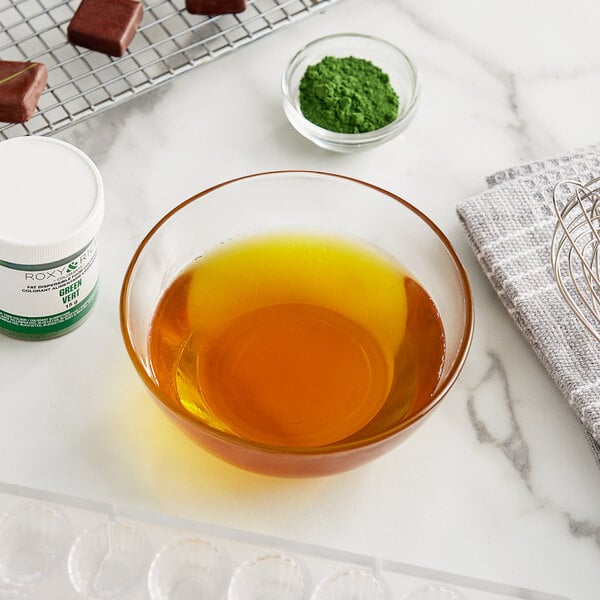 A white bowl of brown liquid next to a wire rack of Roxy & Rich green tea chocolates.