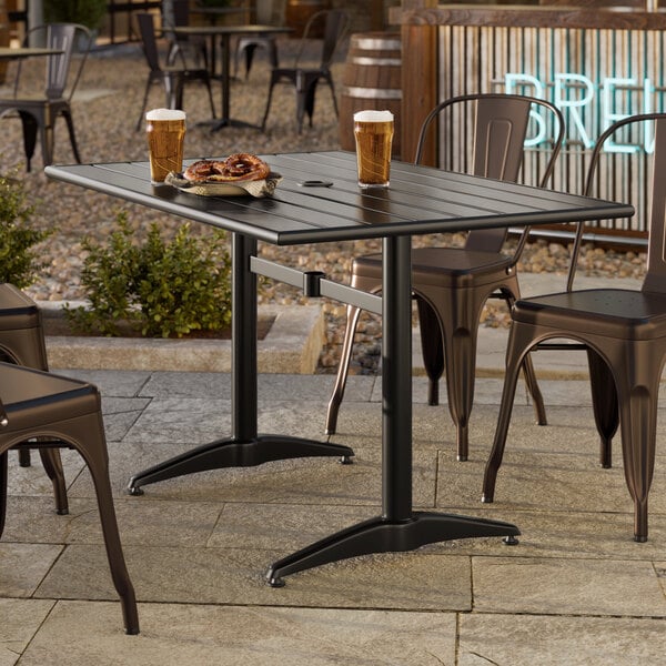 A rectangular black powder-coated aluminum outdoor dining table with an umbrella hole.