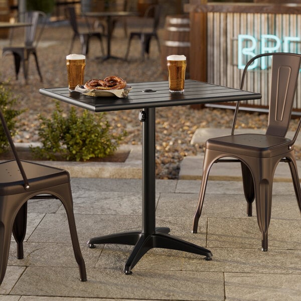 A rectangular black powder-coated aluminum outdoor dining table with an umbrella hole.