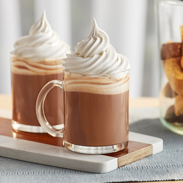 Two glasses of Land O Lakes Mint and Chocolate hot cocoa with whipped cream on top.