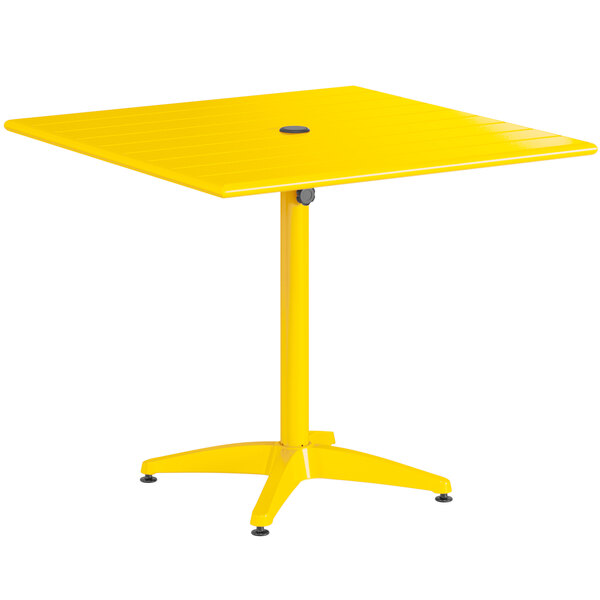 A yellow square Lancaster Table & Seating outdoor table with a round umbrella hole.