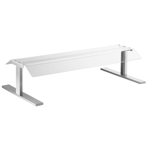 A clear glass and metal Pass-Through Countertop Sneeze Guard on a white rectangular table.
