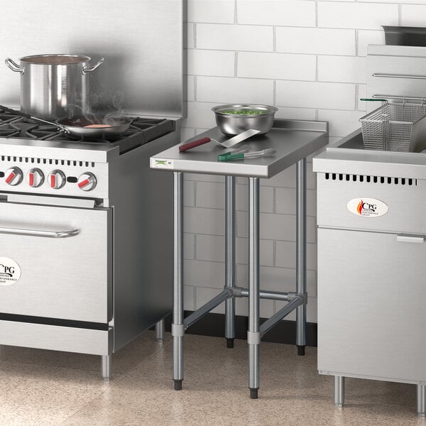 A Regency stainless steel filler table in a kitchen with a stove.