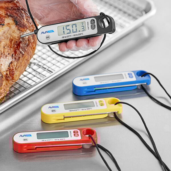 A hand using the AvaTemp Black Digital Folding Probe Thermometer to check the temperature of meat.