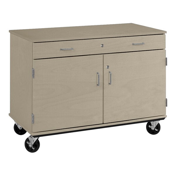 A natural elm I.D. Systems mobile storage cabinet with two doors and a drawer on black wheels.