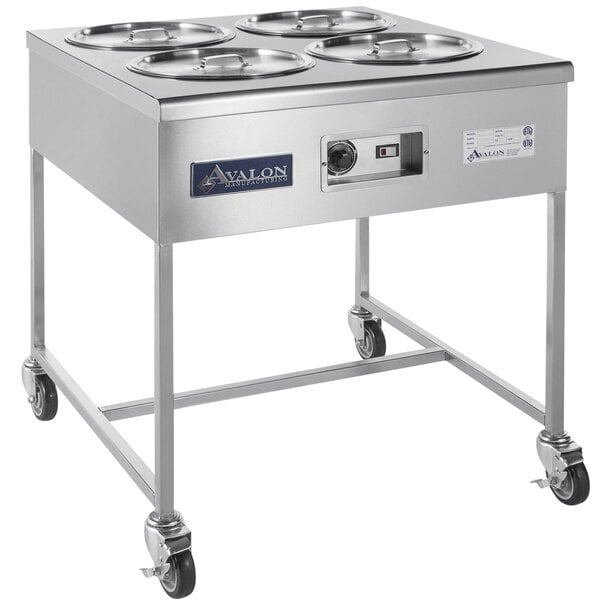 A stainless steel hot icing station with four icing bowls on a counter.