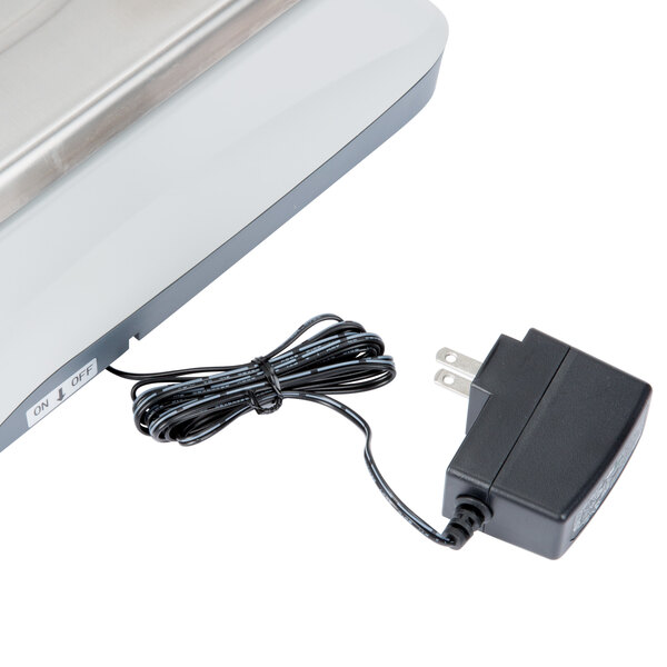 A silver Cardinal Detecto digital counting scale with a black cord plugged in.