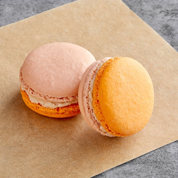 Two Chai Latte Macarons on a brown paper.